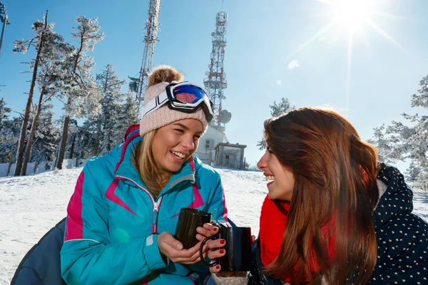 Amies profitant d'une boisson chaude dans un café à la station de ski — Photo