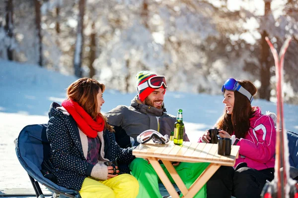Amigos sorridentes passando tempo juntos e beber depois de esquiar — Fotografia de Stock