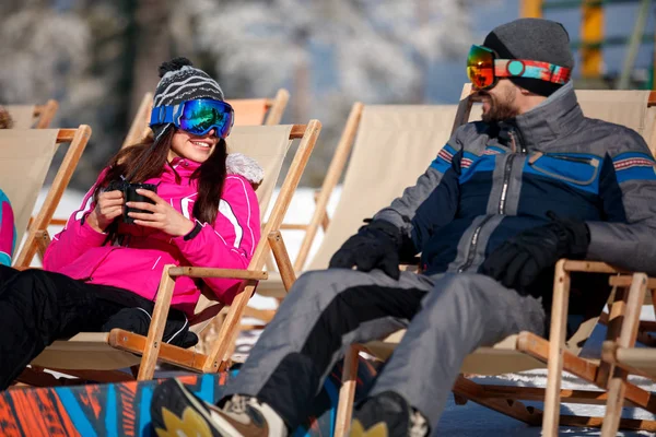 Esquiadores casal relaxar em cadeiras no topo da montanha — Fotografia de Stock