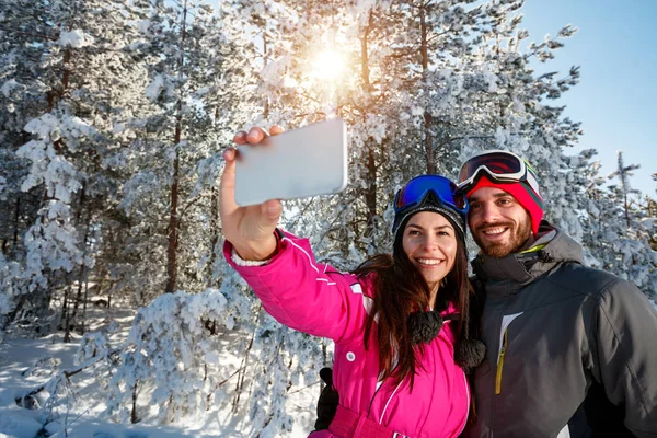 Пара розважається на снігу і робить селфі — стокове фото