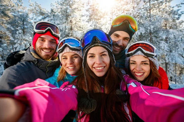 Friends skiers on winter holidays taking photo with mobile phone — Stock Photo, Image
