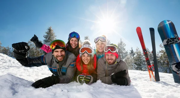 Lachende vrienden plezier op skivakantie in de bergen — Stockfoto