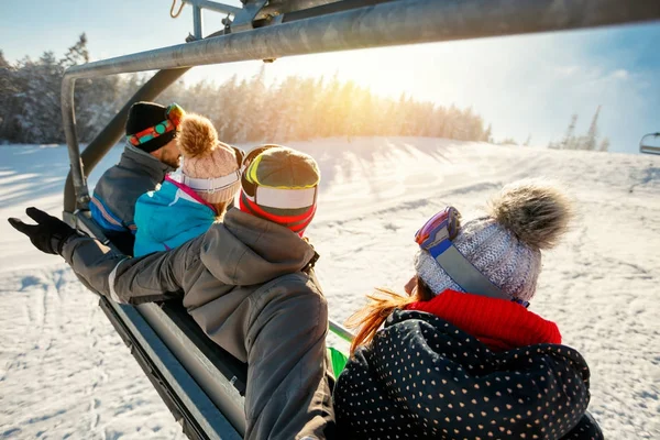 Skiers and snowboarders on ski lift in the mountain at winter vacations Stock Photo