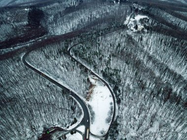 Karlı ormanı ve yol. Bir dron üzerinden havadan görünümü 