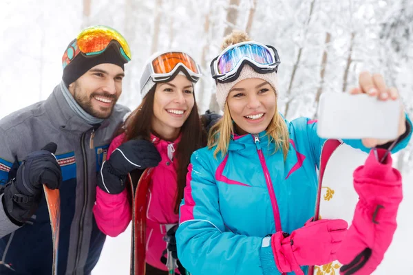 Frau mit Freunden macht Selfie beim Skifahren — Stockfoto