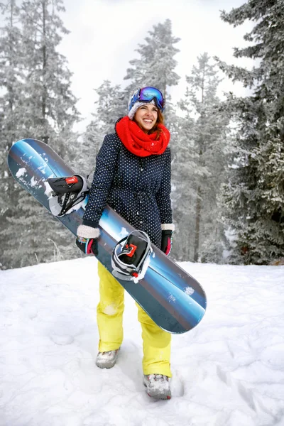Женщина держит сноуборд в горах — стоковое фото