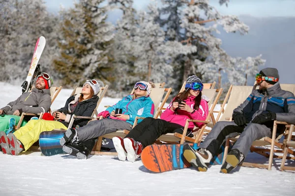 Esquiadores en el sol mal sentado y haciendo una pausa para esquiar — Foto de Stock