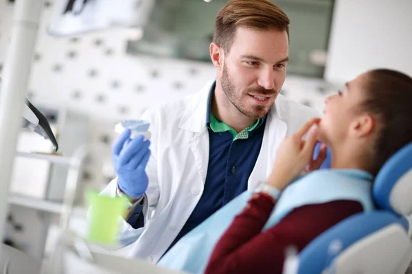 Dentista mirando dientes de hembra —  Fotos de Stock