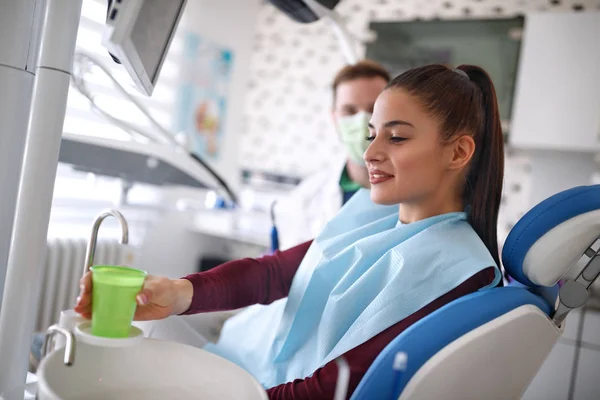 歯科用椅子に座って水を取って女性 — ストック写真