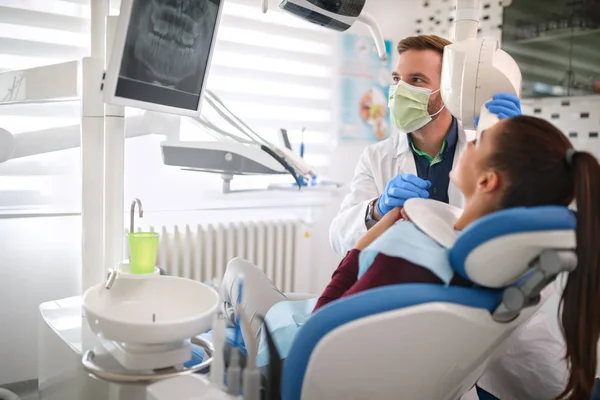 Οδοντίατρος και ασθενή βλέπουν x-ray οδοντιατρική πλάνα — Φωτογραφία Αρχείου