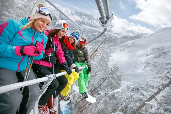 Przyjaciele są do podnoszenia na Wyciąg narciarski dla narciarzy w górach — Zdjęcie stockowe