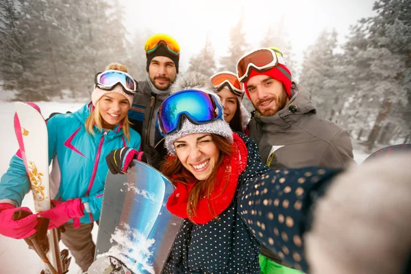 Grupo de amigos felices divirtiéndose Snowboarders y esquiadores haciendo selfie — Foto de Stock
