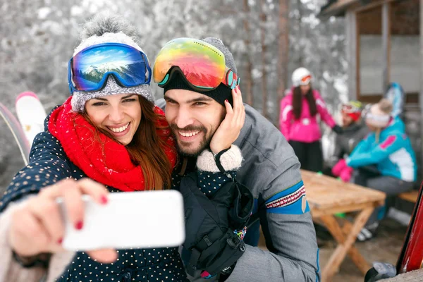 Paar nemen selfie samen met mobiele telefoon in de besneeuwde berg — Stockfoto