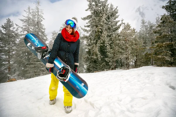Flicka med snowboard utomhus - vinter resort — Stockfoto