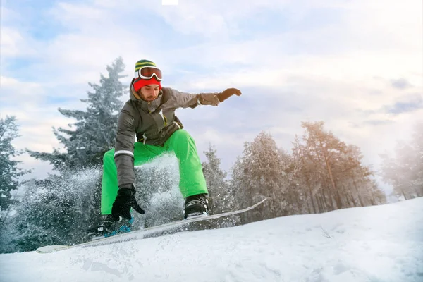 Snowboarder em salto na estância de esqui na montanha — Fotografia de Stock