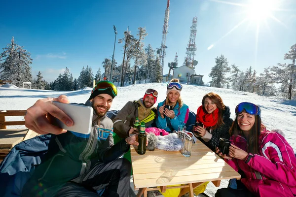 Amigos felizes tomando selfie no café na estância de esqui — Fotografia de Stock