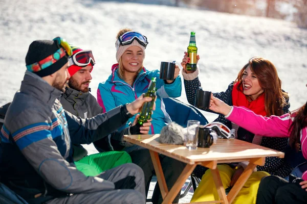 Glückliche Freunde jubeln nach Skitag mit Bier im Skicafé — Stockfoto