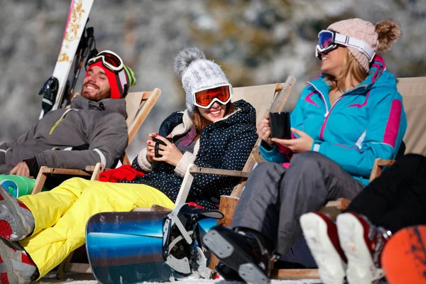 Amies dégustant une boisson chaude dans un café à la station de ski. Bain de soleil — Photo