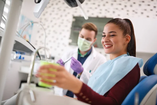 Female in dental ambulant taking cup of water — Stock Photo, Image