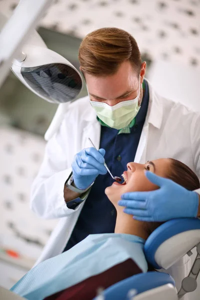 Dentista a verificar os dentes da mulher — Fotografia de Stock