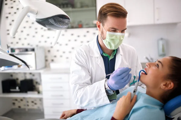 Zahnarzt checkt Patientin im Zahnarztstuhl — Stockfoto