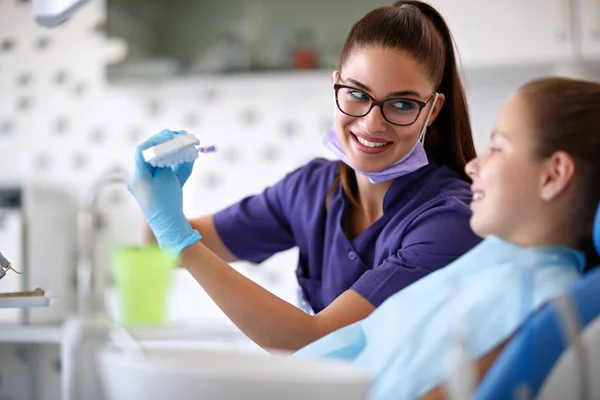 Mujer mostrar cómo cepillar correctamente los dientes en el modelo de mandíbula — Foto de Stock