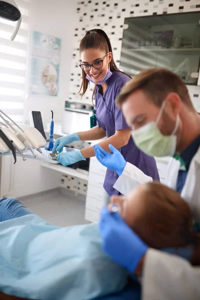 Asistente dental y dentista que trabaja con el paciente — Foto de Stock
