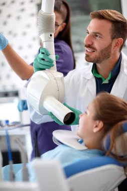 Erkek diş hekimi x-ışını tüpü çocuğun toot görüntülerini yapmak için hazırlar