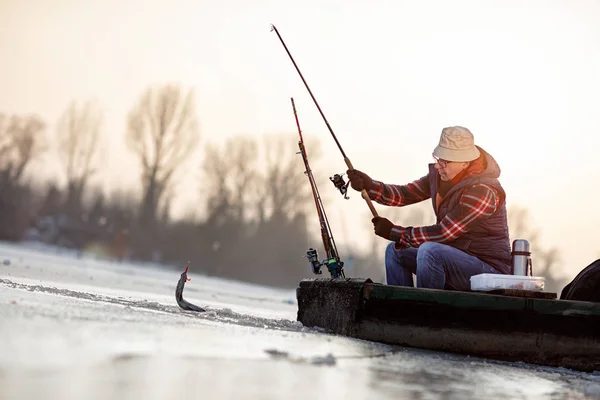 Pesca no gelo no lago congelado- peixe de captura de pescador — Fotografia de Stock