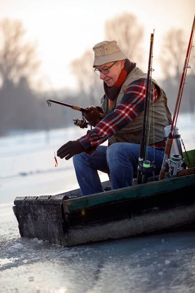 Homem na pesca de inverno no lago congelado — Fotografia de Stock