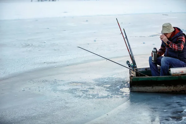 Hombre mayor en invierno pesca beber té en el lago congelado — Foto de Stock