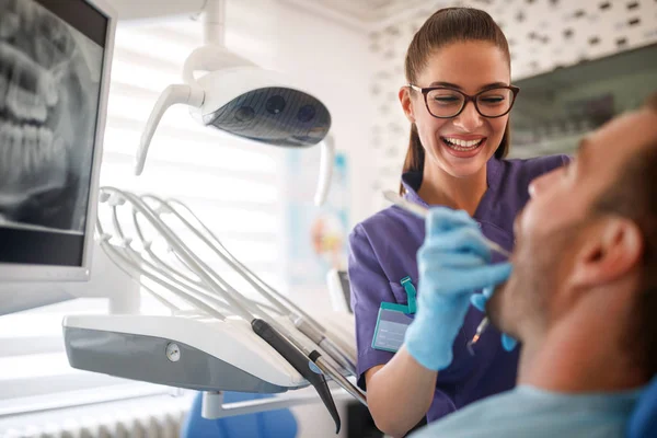 Dentiste féminine réparant la dent du patient — Photo