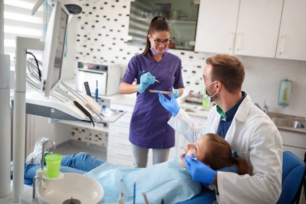Ordenação dentária com paciente jovem em cadeira dentária com médico e assistente — Fotografia de Stock