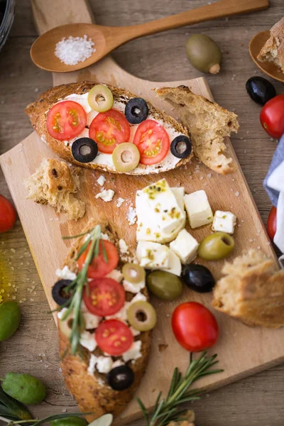 Gezonde mediterrane vegetarische bruschetta op houten snijplank met groente — Stockfoto