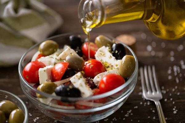 Gieten van olie van eerste persing op vegetarische salade met verse groente — Stockfoto