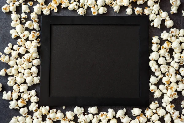 Popcorn med svart ombord - kopia utrymme — Stockfoto