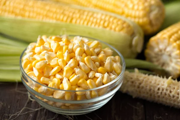 Sweet corn grain in bowl on wooden table — Stock Photo, Image