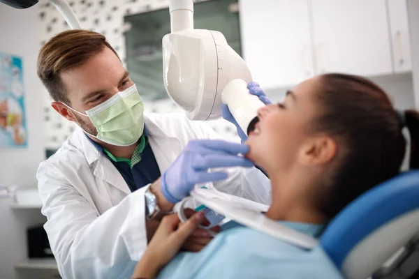 Médico dentário olhando os dentes do paciente — Fotografia de Stock