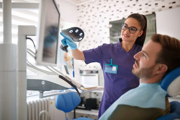 Dentista mostrando dente problemático em imagens de raios-x — Fotografia de Stock