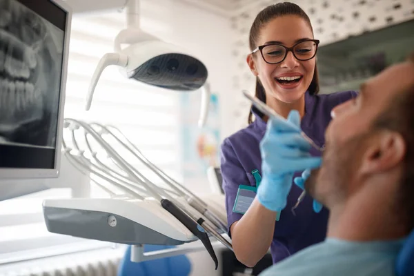 Dentiste travaillant avec le patient en clinique dentaire — Photo