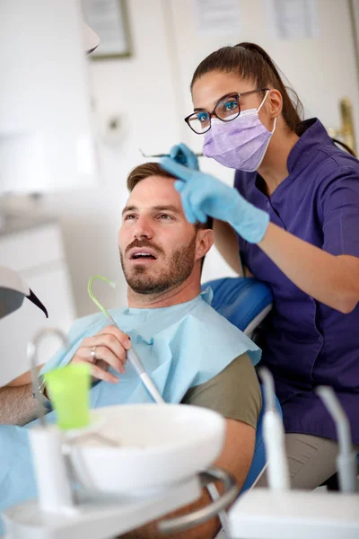 Dentysta rozmawiać z pacjentem jego zęby — Zdjęcie stockowe