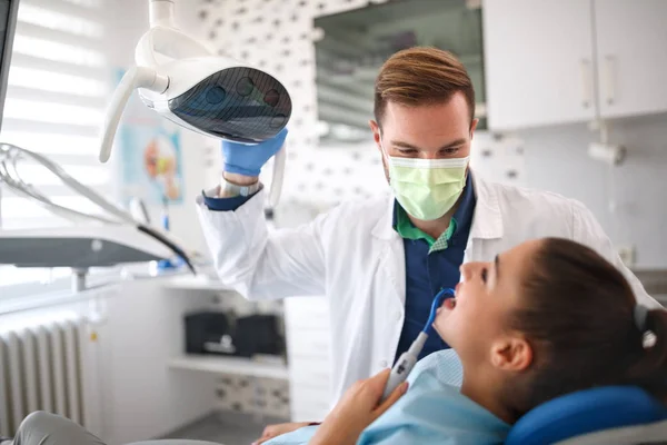 Dentista examinando menina na clínica — Fotografia de Stock