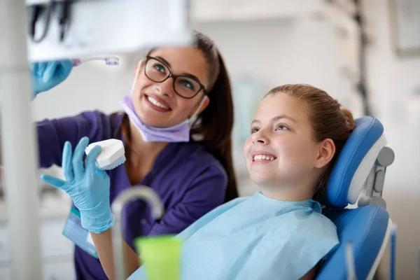 Tandläkare prata om rengöring käken med patienten — Stockfoto