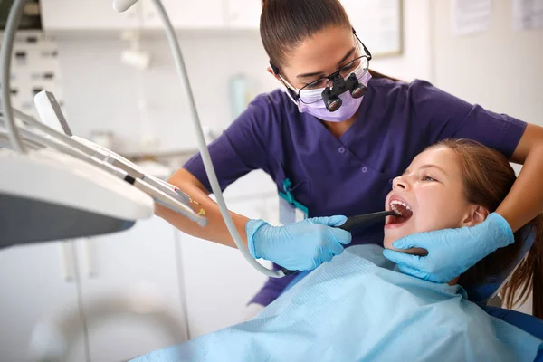 Zahnarzt repariert Zähne von Mädchen — Stockfoto