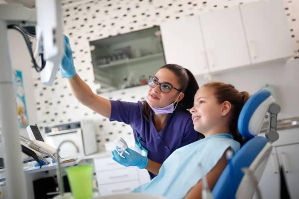 Zahnärztin zeigt auf Röntgenaufnahmen Patientin ihr Problem mit Zähnen — Stockfoto