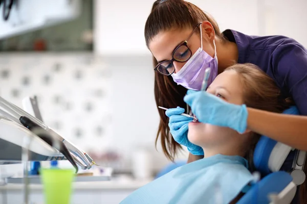 Dentista em ordenação dentária com menina em cadeira dentária — Fotografia de Stock