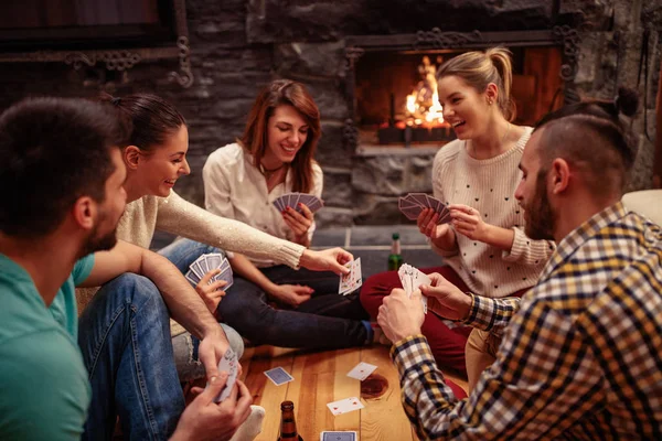 Amigos sorridentes festejando juntos e jogando cartas — Fotografia de Stock