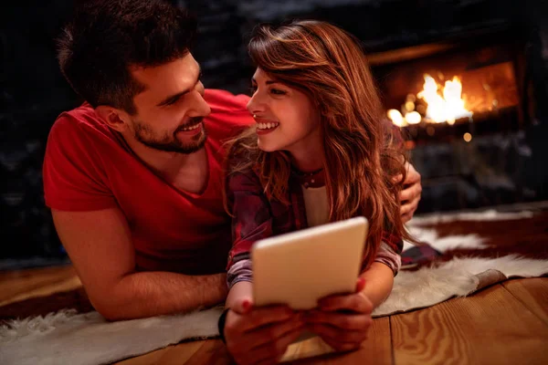 Casal romântico deitado no chão e usando tablet em casa — Fotografia de Stock