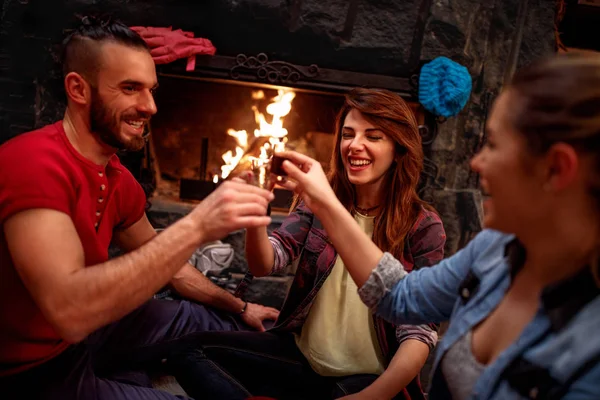 Smiling friends cheering with drinks after skiing day — Stock Photo, Image