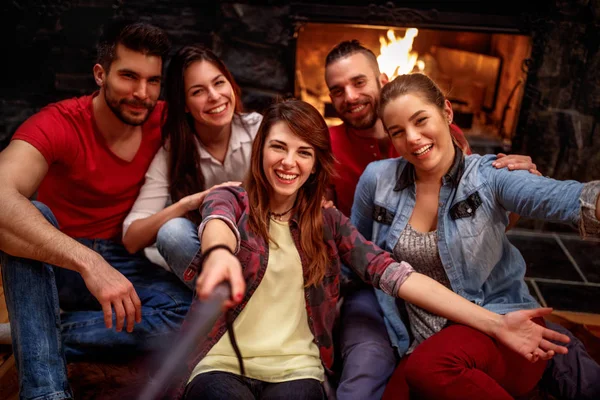 Des jeunes souriants prenant des selfies avec un téléphone portable — Photo